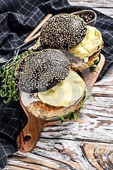 Burger with a black bun brioche, scrambled eggs, beef Patty and arugula. White background. Top view photo