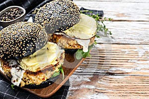 Burger with a black bun brioche, scrambled eggs, beef Patty and arugula. White background. Top view. Copy space photo