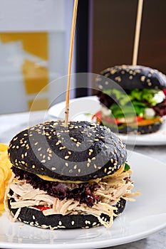 Burger with black bun and torn turkey. Two black burgers. Christmas Turkey Burgers. Thanksgiving day