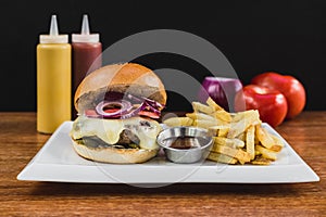 Burger with cheese, onion, bacon, pickle, french fries, bbq, ketchup and mayonnaise