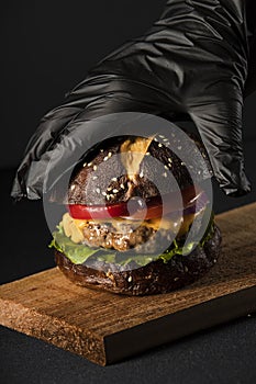 Burger with cheese onion black bread  salad tomato photo