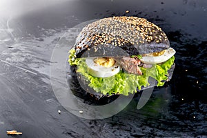 Burger with cheese, salad, fish, eggs and vegetables