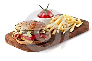 Burger with chicken cutlet, fried bacon and vegetables, French fries, on a wooden board, white background, no people