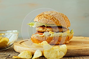 Burger and chips on wooden plate horizontal