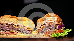 Burger is cooking on black background in black food gloves. Very luscious air bun and marbled beef. Restaurant where