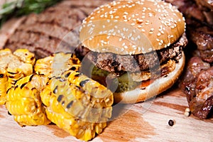 Burger with corn on wooden board