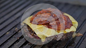 Burger flipped on the stone grill. Preparing of the burger