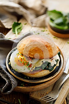 Burger with fried egg and spinach, close up view