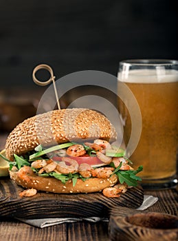 Burger with grilled shrimp and a glass of light beer
