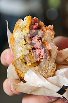 Half-eaten burger in a hand