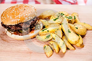 Burger with idaho potatoes on wooden board