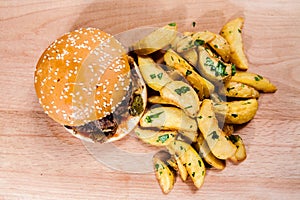 Burger with idaho potatoes on wooden board