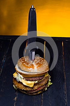Burger with meat pierced with a knife. View of the burger from above photo