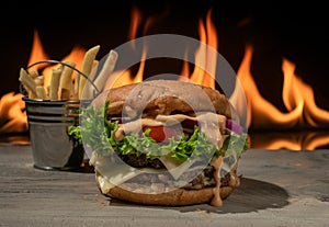 Burger with potatoes in bucket. serving on a dark wooden background
