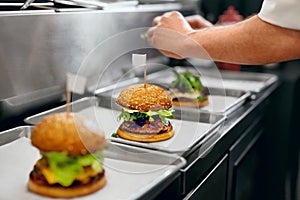 Burger Restaurant. Closeup Chef Cooking Burgers In Kitchen.