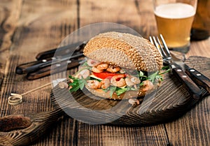 Burger with seafood on the old board with lager