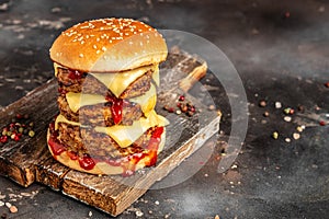 burger triple cheeseburger with beef patty, melted cheese. on a wooden board, Hamburger. Fast food concept