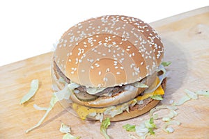 Burger on a white background. Cutlets bun sesame, cheese salad dressing. Improper nutrition. Unhealthy food