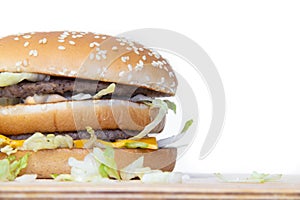 Burger on a white background. Cutlets bun sesame, cheese salad dressing. Improper nutrition. Unhealthy food