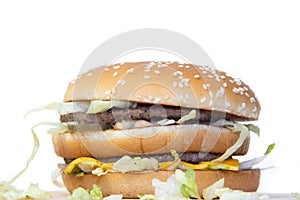 Burger on a white background. Cutlets bun sesame, cheese salad dressing. Improper nutrition. Unhealthy food