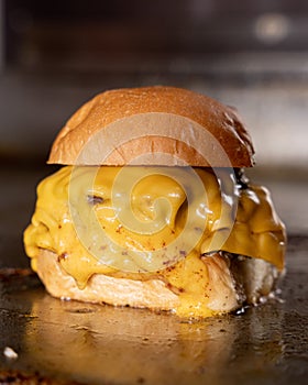 burger with yellow cheese on the griddle