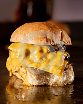 burger with yellow cheese on the griddle