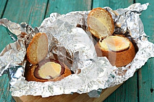 Burgers with baked eggs and ham in foil