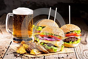 Burgers with beef and fried potatoes and glass of cold beer photo