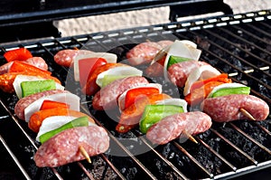 Burgers, Beef and Sausages on a grill with flames