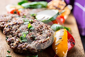 Burgers. Grill burgers. Minced burgers. Roasted burgers with grilled vegetable and herb decoration. Minced meat grilled in a hotel photo