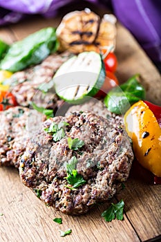 Burgers. Grill burgers. Minced burgers. Roasted burgers with grilled vegetable and herb decoration. Minced meat grilled in a hotel