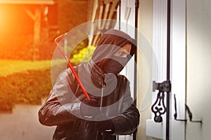 Burglar breaking in a house