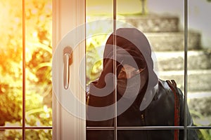 Burglar breaking in a house