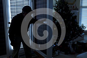 Burglar Breaking In To Home At Christmas Through B