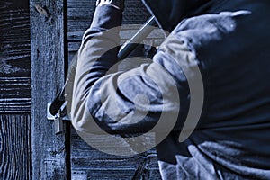 A burglar breaks a lock with a bolt cutter