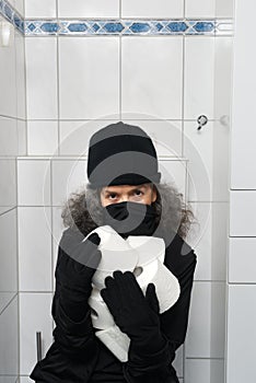 Burglar with coveted Toilet paper rolls in arms Coronavirus