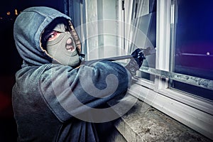 Burglar with crowbar break door to enter the house