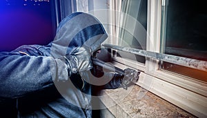Burglar with crowbar break door to enter the house