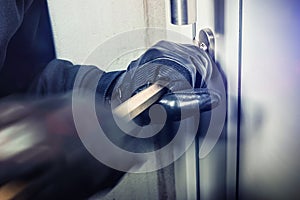 Burglar with crowbar break door to enter the house