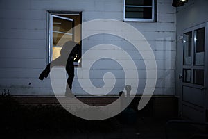 Burglar Entering In A House Through A Window photo