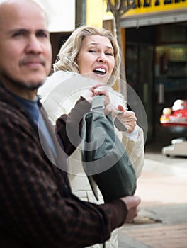 Burglar stealing bag of female pensioner