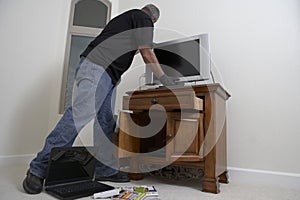 Burglar Stealing Television From House