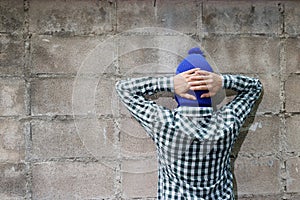 Burglar surrenders against brick wall background