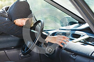 Burglar thief breaking into car stealing smartphone