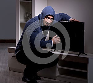 Burglar thief stealing tv from apartment house