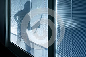 Burglar wearing a balaclava looking through window