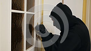 Burglar wearing balaclava mask at crime scene. Housing thief. Burglar in a house inhabited