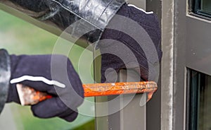 Burglar wearing leather coat breaking in a house