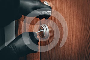 Burglary of an apartment, a thief in black gloves, opening the door with a lockpick