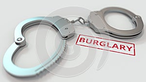 BURGLARY stamp and handcuffs. Crime and punishment related conceptual 3D rendering